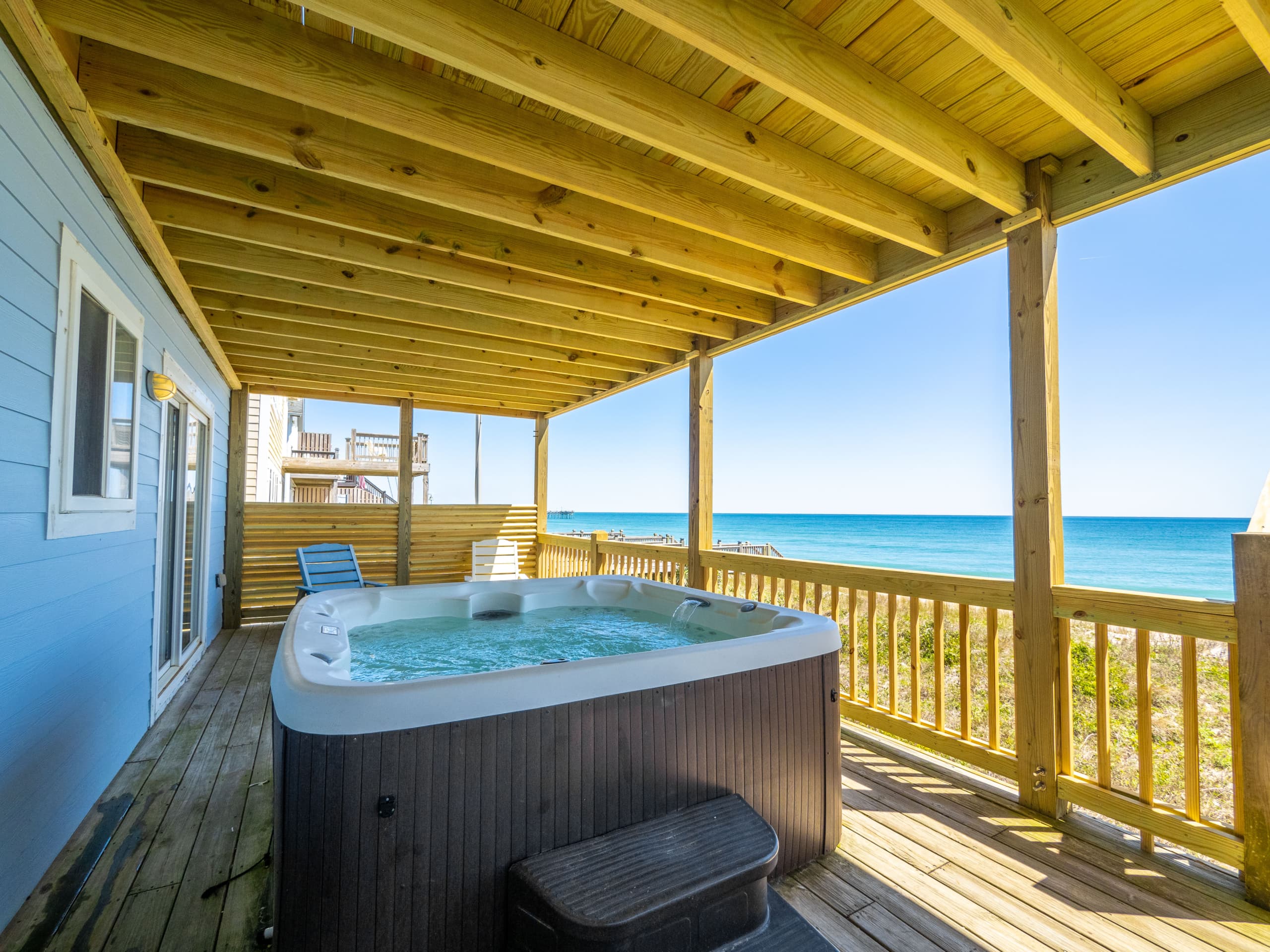 Soak in your private hot tub under the covered patio and watch the turquoise waves roll in