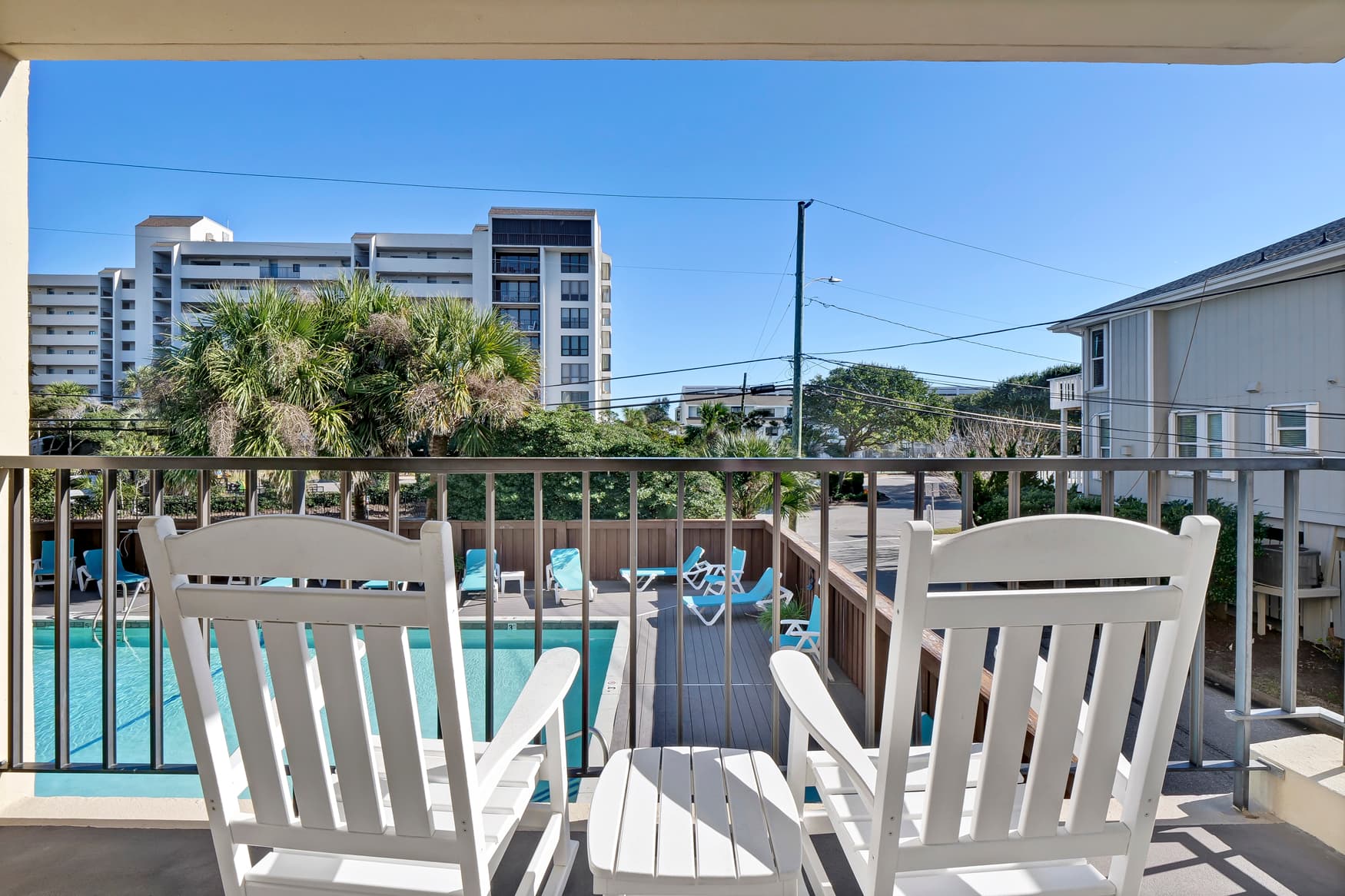 Relax on your private balcony with pool views and comfortable seating, perfect for morning coffee or evening unwinding.