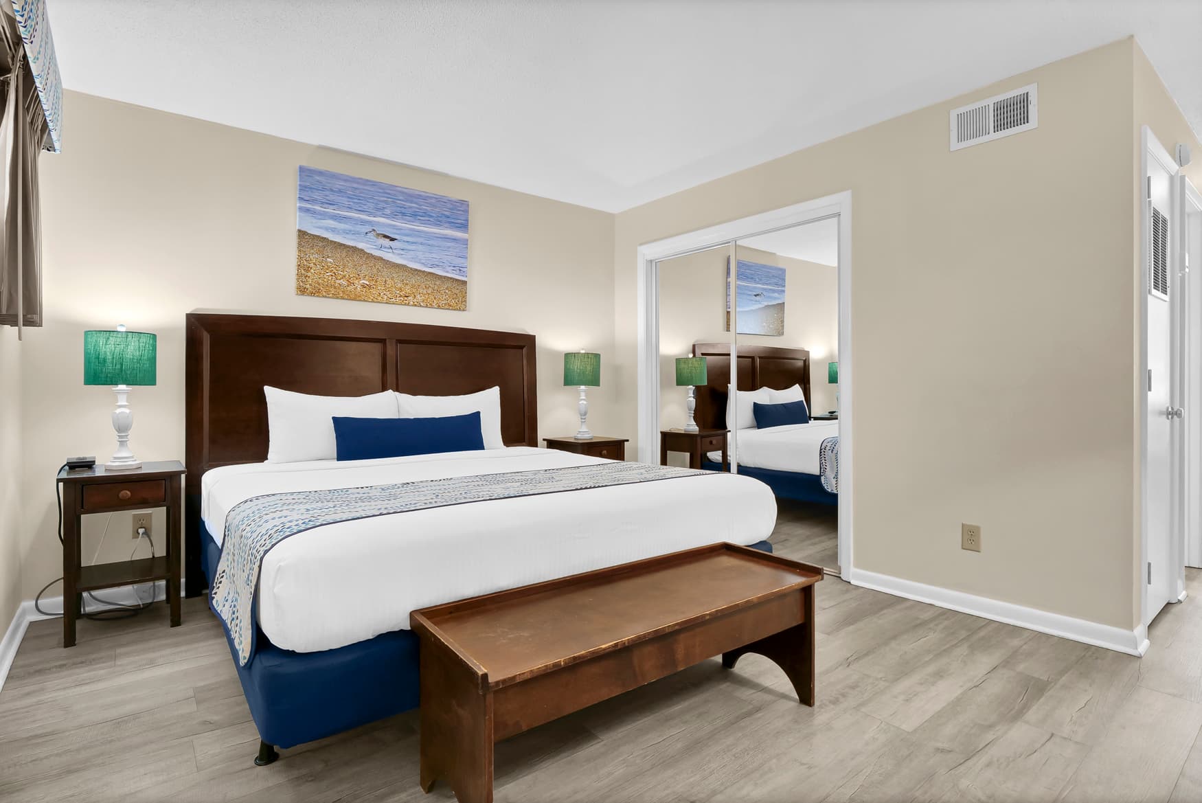 Unwind in your spacious bedroom suite featuring a plush king bed, coastal artwork, and elegant furnishings that create the perfect retreat.
