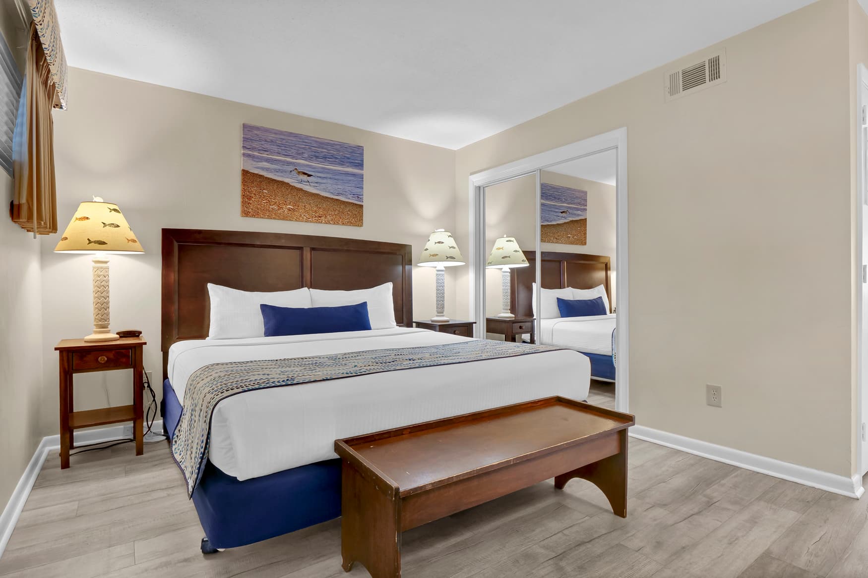 Unwind in your peaceful bedroom featuring a comfortable king bed, coastal artwork, and elegant furnishings that create the perfect retreat for a restful night's sleep.