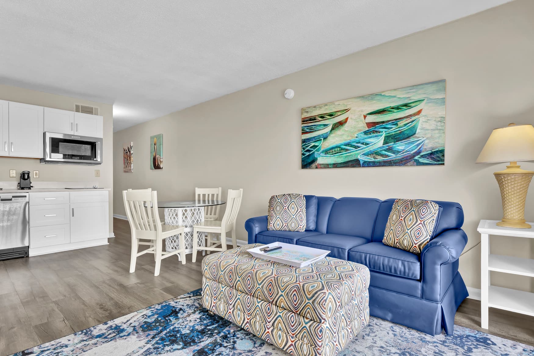 Sink into your plush blue sofa and enjoy coastal artwork while your open kitchen awaits morning coffee brewing.