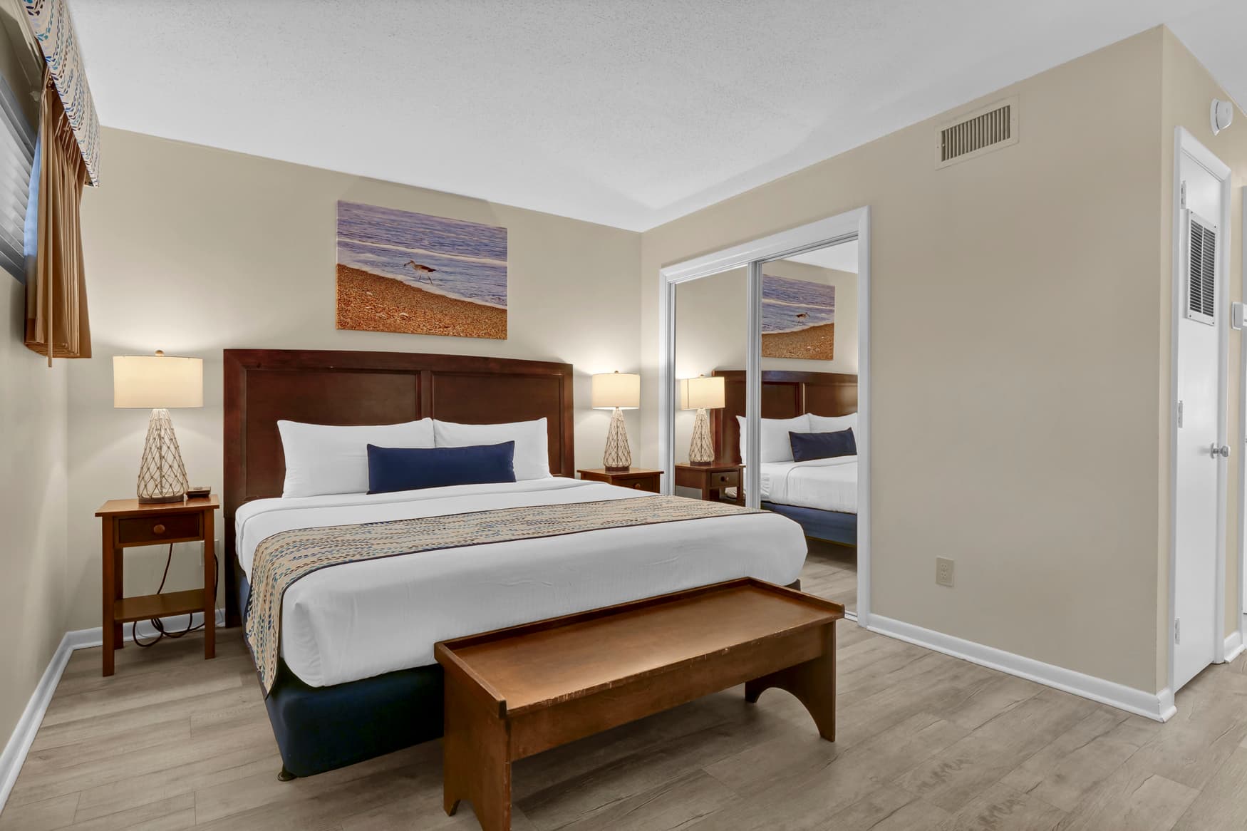 Relax in your comfortable bedroom featuring crisp white linens, warm wood furnishings, and thoughtful coastal touches that create the perfect retreat after your day.