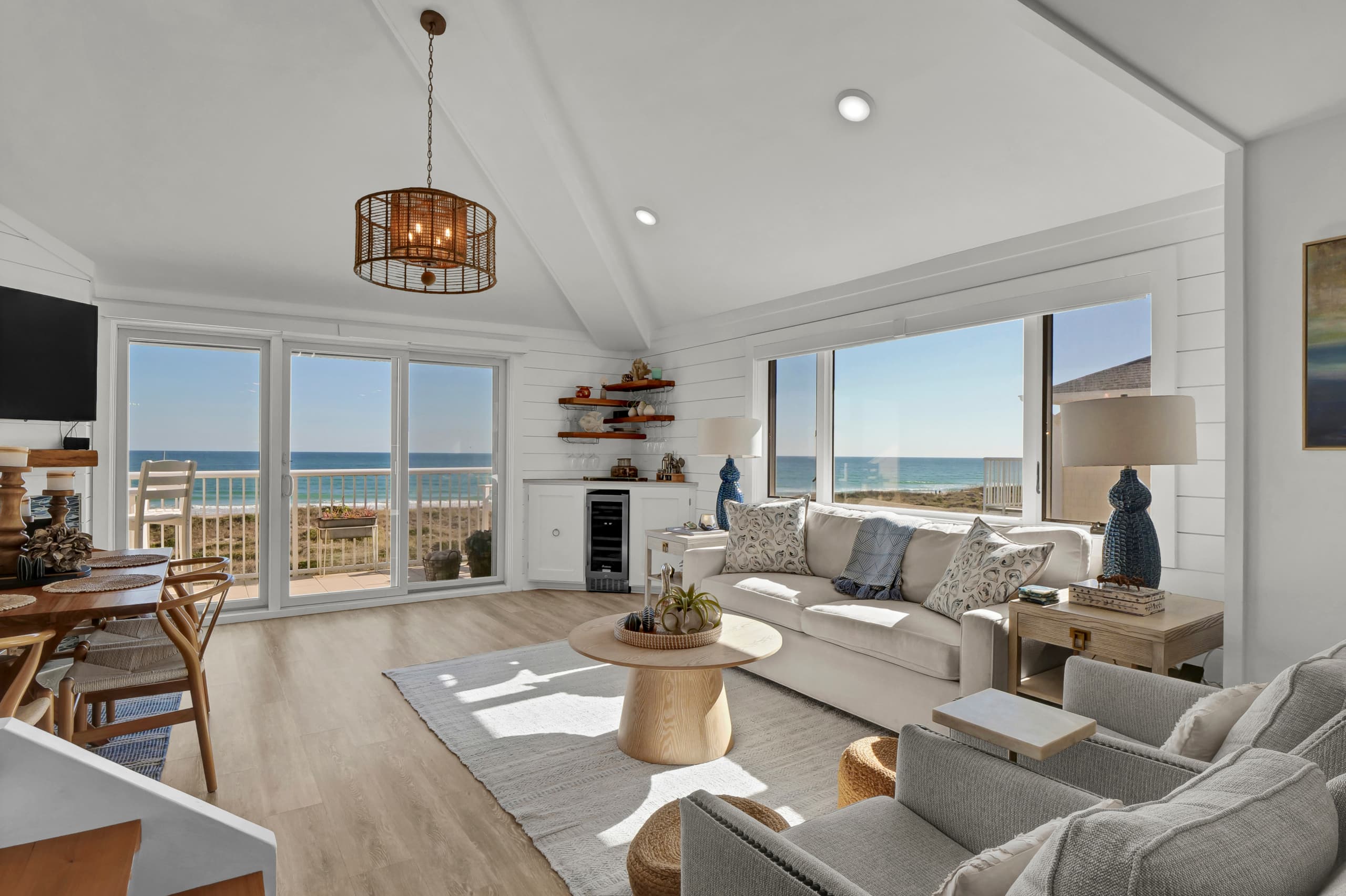 Bright oceanfront living room with panoramic shoreline views