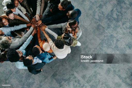 Team stacking hands together seen from above
