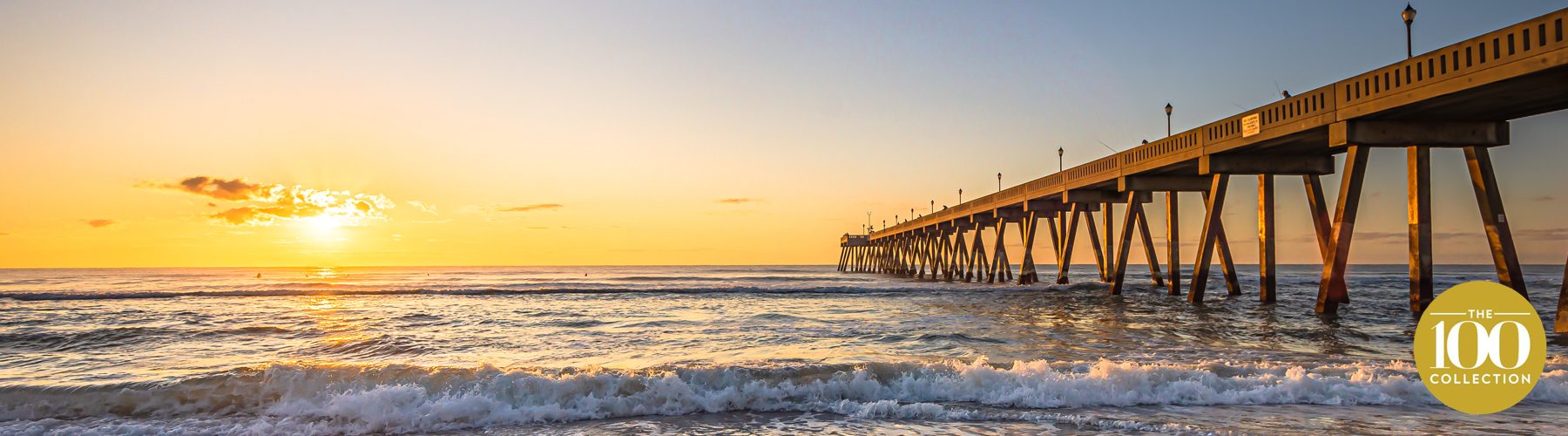 Wooden pier at Wrightsville Beach glowing at sunset