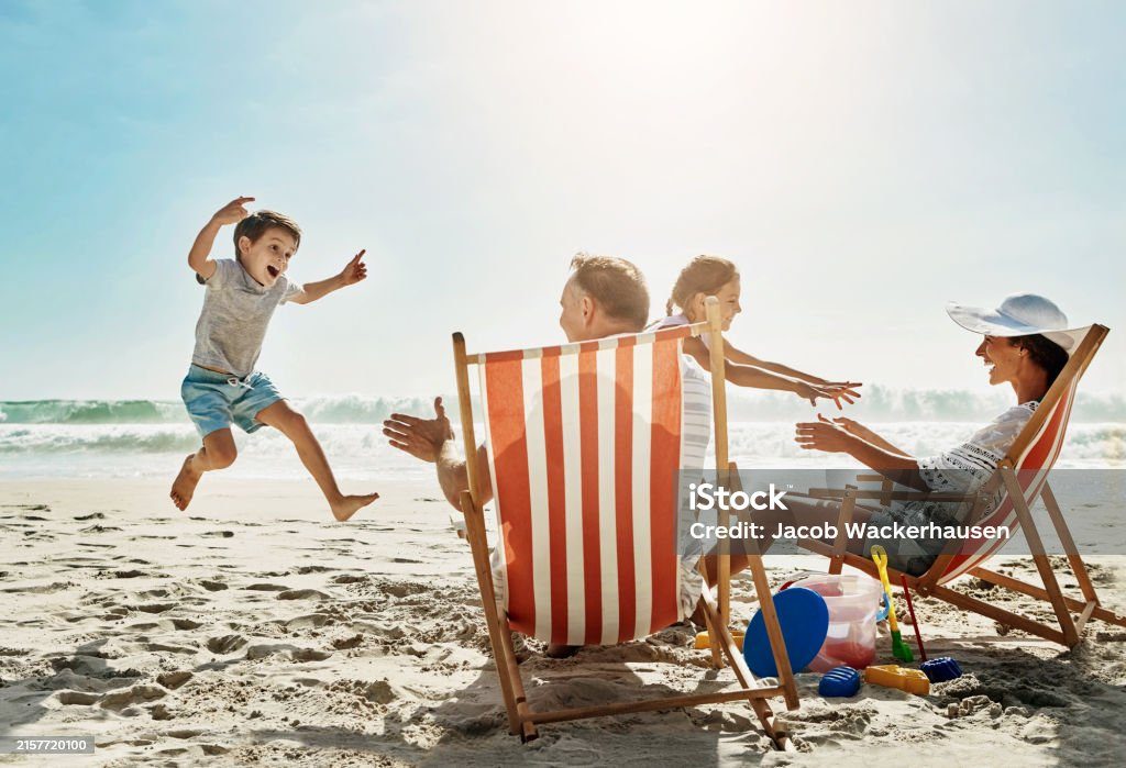 Friends enjoying striped deck chairs on the beach