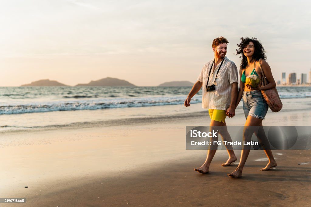 Family walking along the shoreline at sunset