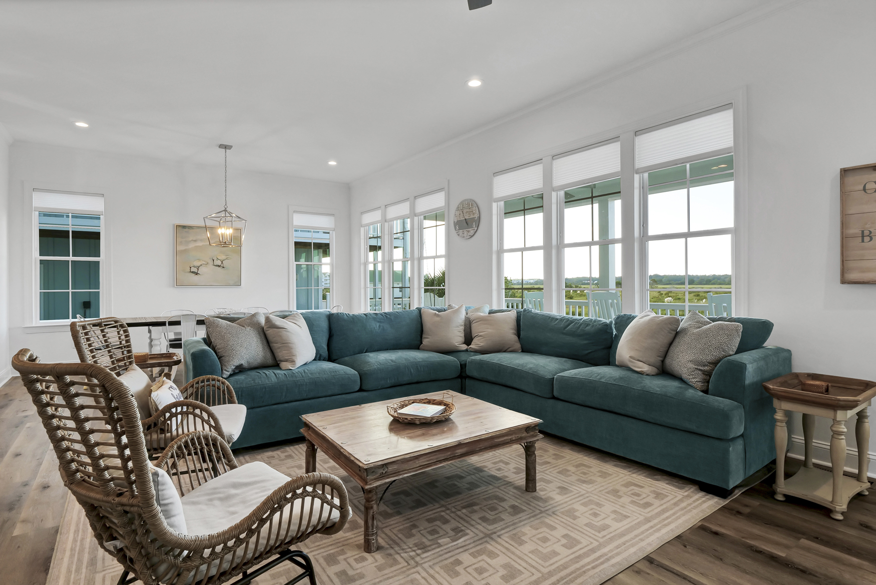 Bright coastal living room with a teal sectional and marsh views